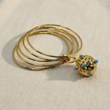Bracciale dorato con pietre azzurre su lino beige, prima foto
