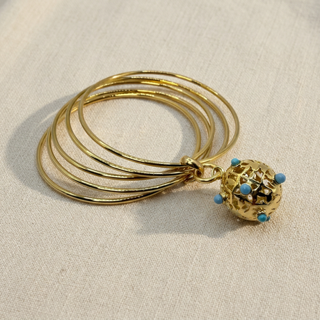 Bracciale dorato con pietre azzurre su lino beige, prima foto